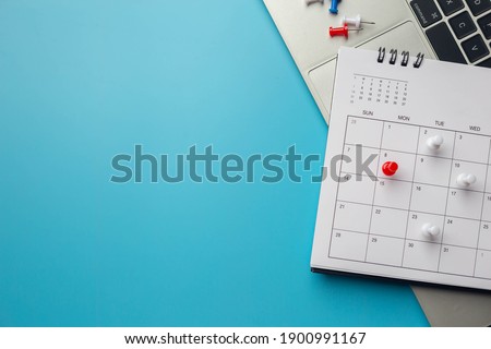Calendar on solid ิblue background with copy space, pinned in a calender on datebusiness meeting schedule, travel planning or project milestone and reminder concept.