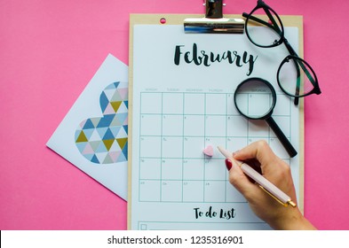 calendar with red mark on 14 February 2019. Valentine's day concept. Pink background. avocado, glasses, top view. place for text.