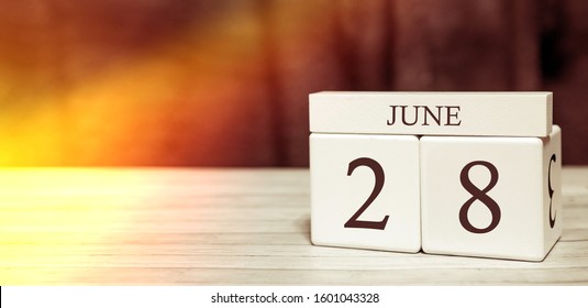 Calendar Reminder Event Concept. Wooden Cubes With Numbers And Month On June 28 With Sunlight.