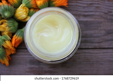 Calendula Cream And Calendula Flowers. Organic Diy Marigold Facial Mask In Glass Jar On Wooden Table. Homemade Natural Organic Cosmetics With Botanical Ingredients. Top View Of Home Beauty Remedies