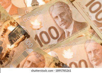 Calgary, Alberta, Canada - January 14, 2021: Canadian Money One Hundred Dollar Paper Bills In A Pile Background. Saving Money During A World Pandemic
