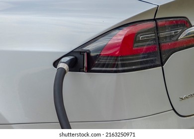 Calgary, Alberta, Canada. Jun 2022. A close up to a Tesla Supercharger stall with charging cable-outlet charging an electric car. 480 volt Supercharging or DC fast charging.