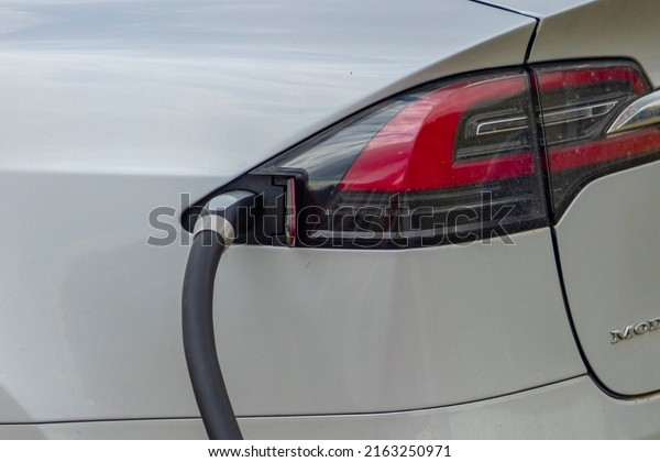 Calgary, Alberta,\
Canada. Jun 2022. A close up to a Tesla Supercharger stall with\
charging cable-outlet charging an electric car. 480 volt\
Supercharging or DC fast\
charging.