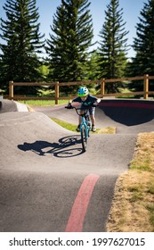 Calgary Alberta Canada, June 25 2021: A young child rides the new South Glenmore Park BMX pump track on his bike on a summer evening in Calgary Alberta Canada.