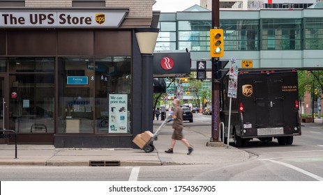 Calgary Alberta, Canada June.6 2020: The UPS Store And UPS Delivery Truck With The Truck Driver Dropping Off Some Packages During Covid19