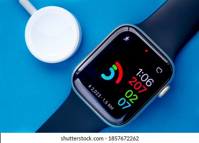 Calgary, Alberta, Canada. Nov. 19, 2020. An Apple Watch Series 6 with the Activity digital and a charger on a blue background.