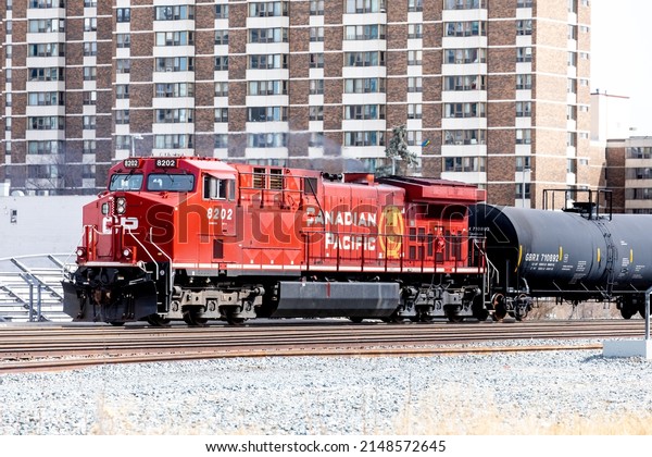 Calgary, Canada, April 18, 2022; A CP Canadian\
Pacific diesel locomotive with a train of crude oil cars passing\
through downtown\
Calgary