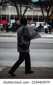 CALGARY, CANADA - Dec 03, 2021: An Elderly Woman Flaunts Her Sign At Counter Protesters Across The Street In Calgary, Canada