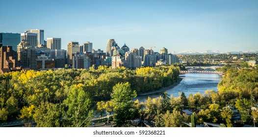 Calgary downtown at morning spring with river in foreground and mountains in background 