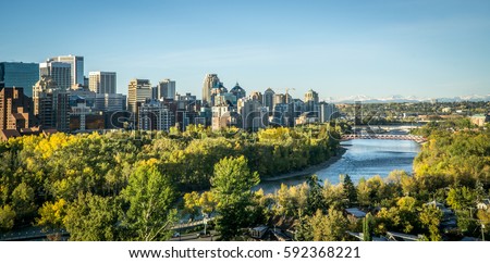 Calgary downtown at morning spring with river in foreground and mountains in background 