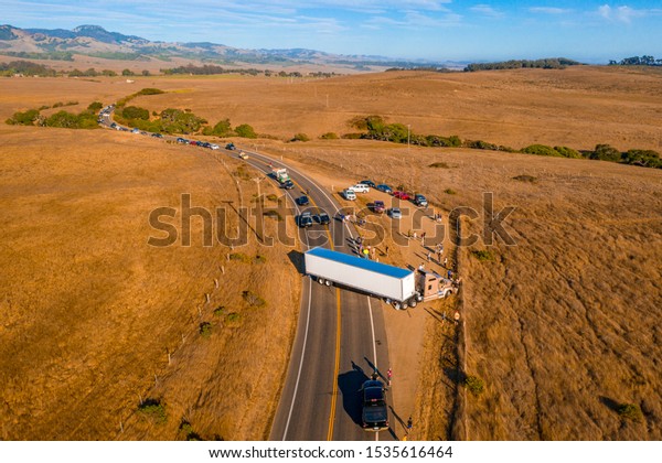 California Highway Traffic. Trucks\
and cars on the Highway 1 are stuck because of the accident. Huge\
truck blocked the road both ways. American transportation\
theme.