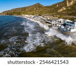 California king tides with crashing waves over rocks and concrete below oceanfront homes. Ventura County Mondo