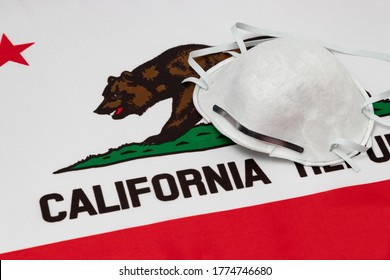 California State Flag And N95 Face Mask. Concept Of State And Local Government Face Covering Mandate, Order, Requirement And Social Distancing During Covid-19 Coronavirus Pandemic