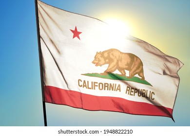 California state of United States flag waving on the wind in front of sun
