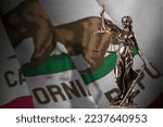 California US state flag with statue of lady justice and judicial scales in dark room. Concept of judgement and punishment, background for jury topics