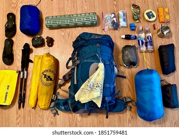 California, USA - 2020: Flat lay of camping, hiking outdoor gear. Osprey bag, trekking poles, Big Agnes tent, REI sleeping bag, Sea to Summit dry bag, Sawyer squeeze, Smart Water, Luci solar light. 