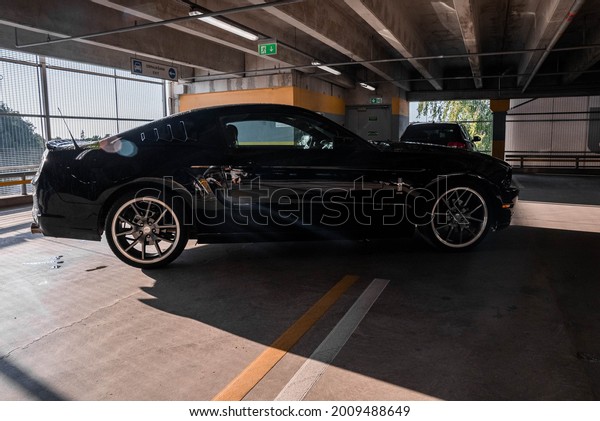 CALIFORNIA, USA JUNE 19, 2021. Black Ford Mustang
model parked. Sporty legendary American muscle car with big black
wheels.