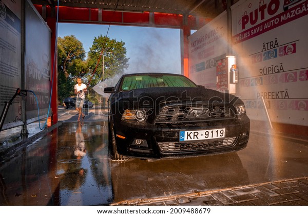 CALIFORNIA, USA JUNE 19, 2021. Black\
Ford Mustang muscle car in a car wash. Washing car\
scene.