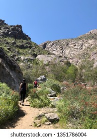 CALIFORNIA, USA - MARCH 24, 2019: People Hike In Tahquitz Canyon, Located In Southern California In The Coachella Valley Near Palm Springs, California. It Is A Bright Sunny Day With Clear Blue Sky.