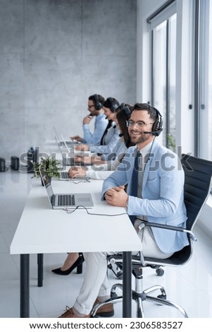 Call center agent engaging in a conversation with a client, with a headset on, the agent attentively listens to the client's needs while surrounded by supportive colleagues.