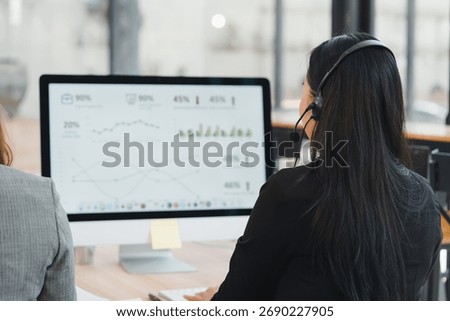 Call center analyst viewing data dashboard on desktop headset customer support multitasking with calm focus