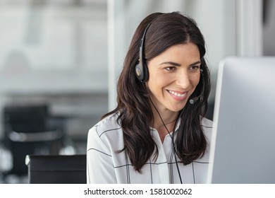 Call center business woman talking on headset. Portrait of mature woman working on computer in office. Smiling telephone operator with headset working on support customer service with copy space.