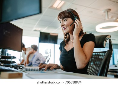 Call center business woman talking on headset. Caucasian female in customer service position talking on the phone.