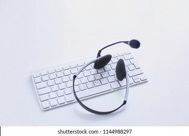 Call Center And Customer Service Help Desk. VOIP Headset On Laptop Computer Keyboard