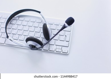 Call Center And Customer Service Help Desk. VOIP Headset On Laptop Computer Keyboard