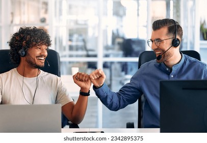 Call center employee accompanied by his team. Focused support operator at work. Young employee working with headset and laptop. - Powered by Shutterstock