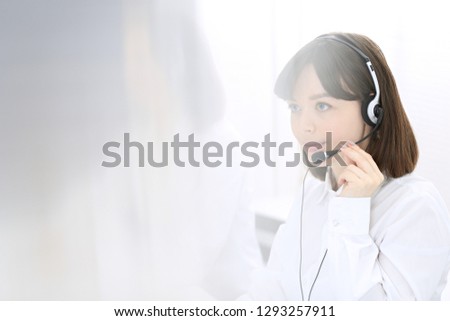 Call center. Group of operators at work. Focus on young brunette woman. Business  concept