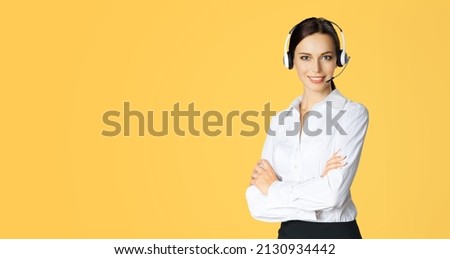 Call center help line service. Studio portrait image of customer support phone sales operator in headset, yellow background. Happy smiling business woman. Caller worker. Skype zoom adviser callcenter.