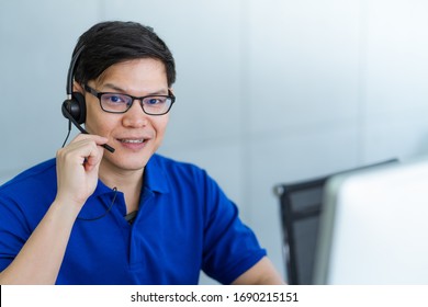 Call Center Man In Blue Shirt Uniform Working Care Customer Service Wearing Headphone Talking With Customer At Call Center Office.Support Customer Team 24 Hours