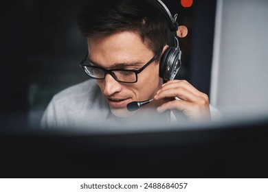 Call center, man and computer with headphones for customer service with communication and FAQ support. Telemarketing, agent and telecom advisory with microphone, contact us and assistance at night - Powered by Shutterstock