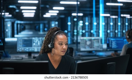 Call Center Office: Portrait of Friendly African American Female Technical Customer Support Specialist Talking on Headset, uses Computer. Client Experience Officer Helps Online via Video Conference - Powered by Shutterstock