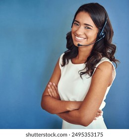 Call center, portrait and businesswoman in studio with headset, telemarketing and customer service. Arms crossed, female agent and mic for communication, advice and support for faq by blue background - Powered by Shutterstock - Get 15% off with code: PIKWIZARD15