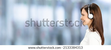 Call center service. Profile side image of customer support phone sales operator in  headset, copy space area for text, standing over blurred office background. Callcenter answering centre service ad.