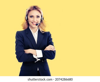 Call center. Smiling female support phone operator in headset, in dark blue confident suit, cross arms pose, over yellow background. Customer service help consulting. Callcenter, callcentre adviser.