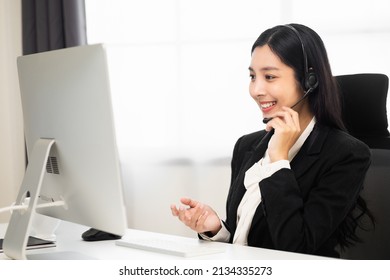 Call Centre Female Operator. Smiling Asian Business Woman Receptionist Wearing Headphone Video Conference Calling Talk By Webcam In Online Chat Customer Support Service.