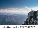 call of nature on the Otscher mountain. The girl in black sportswear stretches on a rock massif. Dangerous place. View of the Austrian Alps. Mountain girl on the edge of a rock.