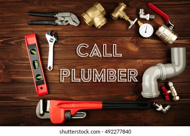 Call Plumber. Plumber tools frame on wooden background