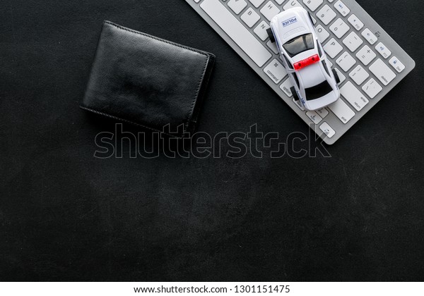 Call police online
concept. Police car toy and computer keyboard on black background
top view copy space