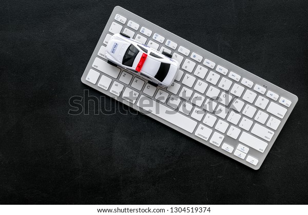 Call police online\
concept. Police car toy and computer keyboard on black background\
top view copy space