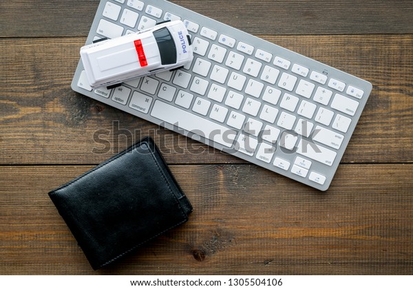Call police
online concept. Police car toy and computer keyboard on dark wooden
background top view space for
text