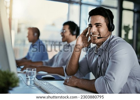 Callcenter agent, smile and man in office consulting with advice, help and happiness at desk. Happy phone call, conversation and service, customer support consultant speaking on headset at crm agency