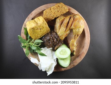 called pecel ayam in Indonesian, served with fried chicken, tempeh and tofu. added with fresh vegetables or lalapan in Indonesian such as basil, cucumber, and cabbage.