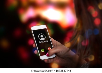 Caller with blocked ID calls someone on cellphone standing in discotheque environment. Incognito harassment through mobile communication concept