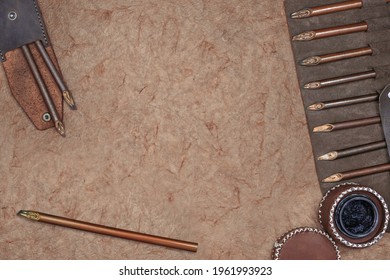 Calligraphy Mockup, Top View Of Inkwell, Leather Pen Case , And Calligraphy Pens On Old Paper Blank With Space For Your Own Writing