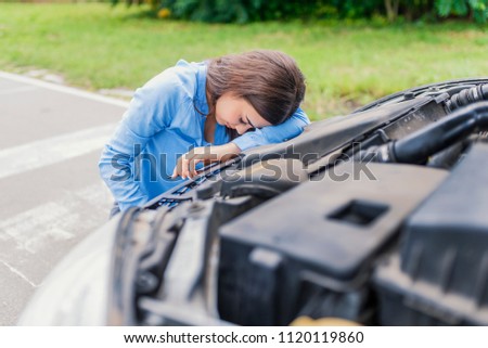 Calling Emergency Service. Car problems. Young woman using mobile phone while looking at broken down car on street. Woman caling autoservice because of car problem
