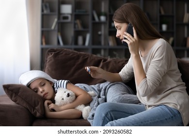 Calling family doctor. Sad sick preteen kid girl lie on couch feel fever catch cold flu influenza. Anxious mother hold phone to ear make call to doc family therapist after measuring child temperature